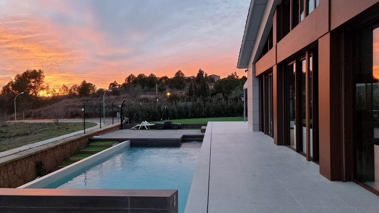 Residencia Igualada: fachada, terraza y piscina al atardecer